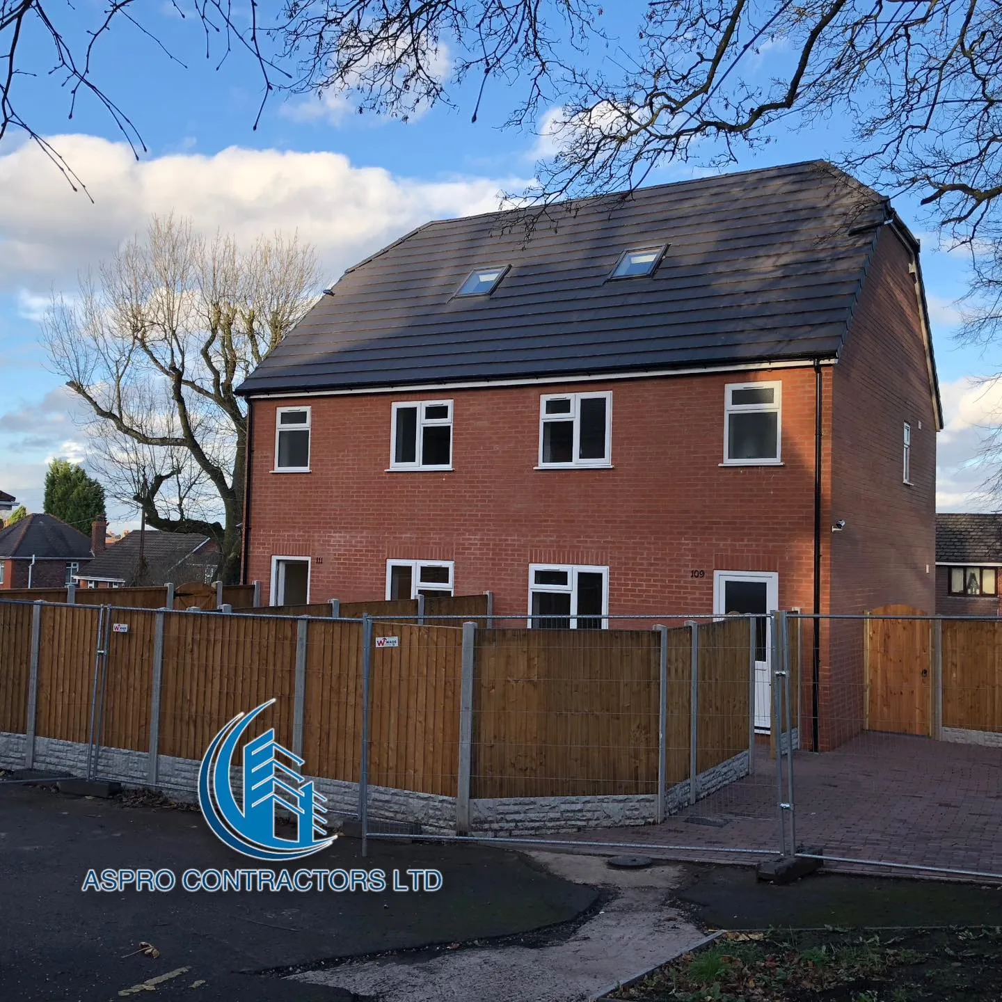 a red brick house with a fence around it